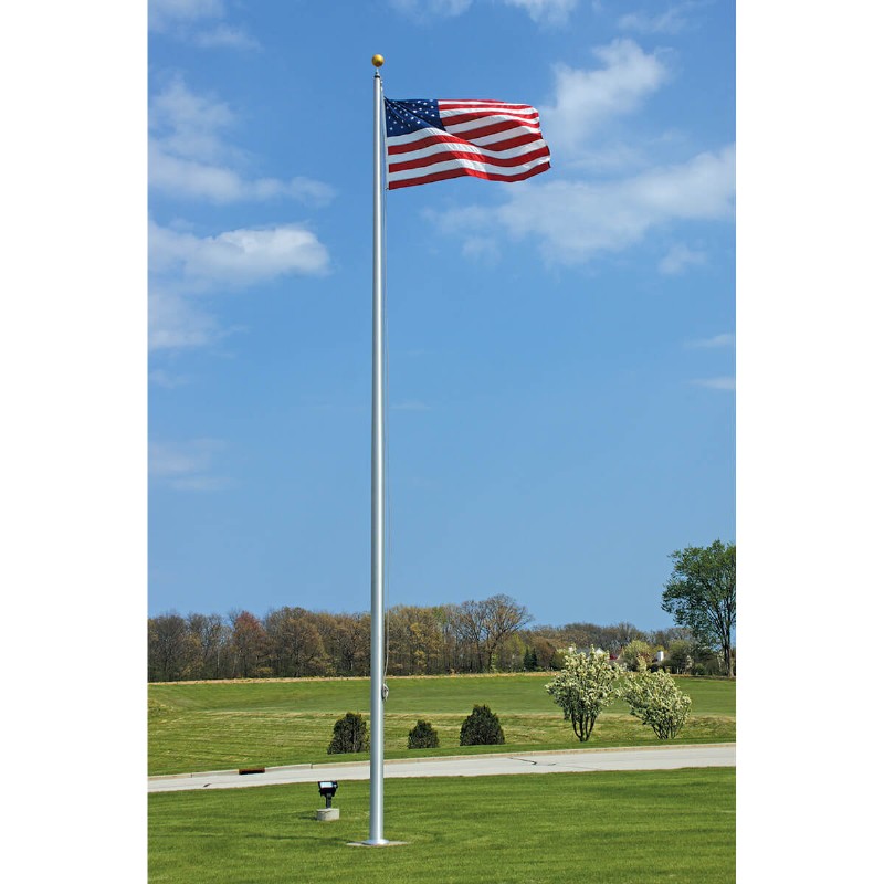Flagpole with an American flag over open grass