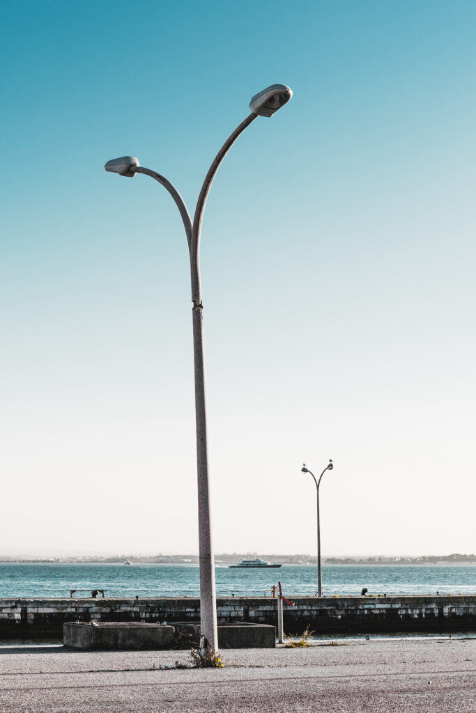 Concrete street light poles along a waterfront walkway