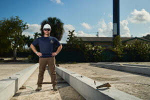 Pole Installers crew member with precast concrete poles on site