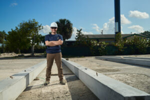 Pole Installers crew member next to precast concrete poles