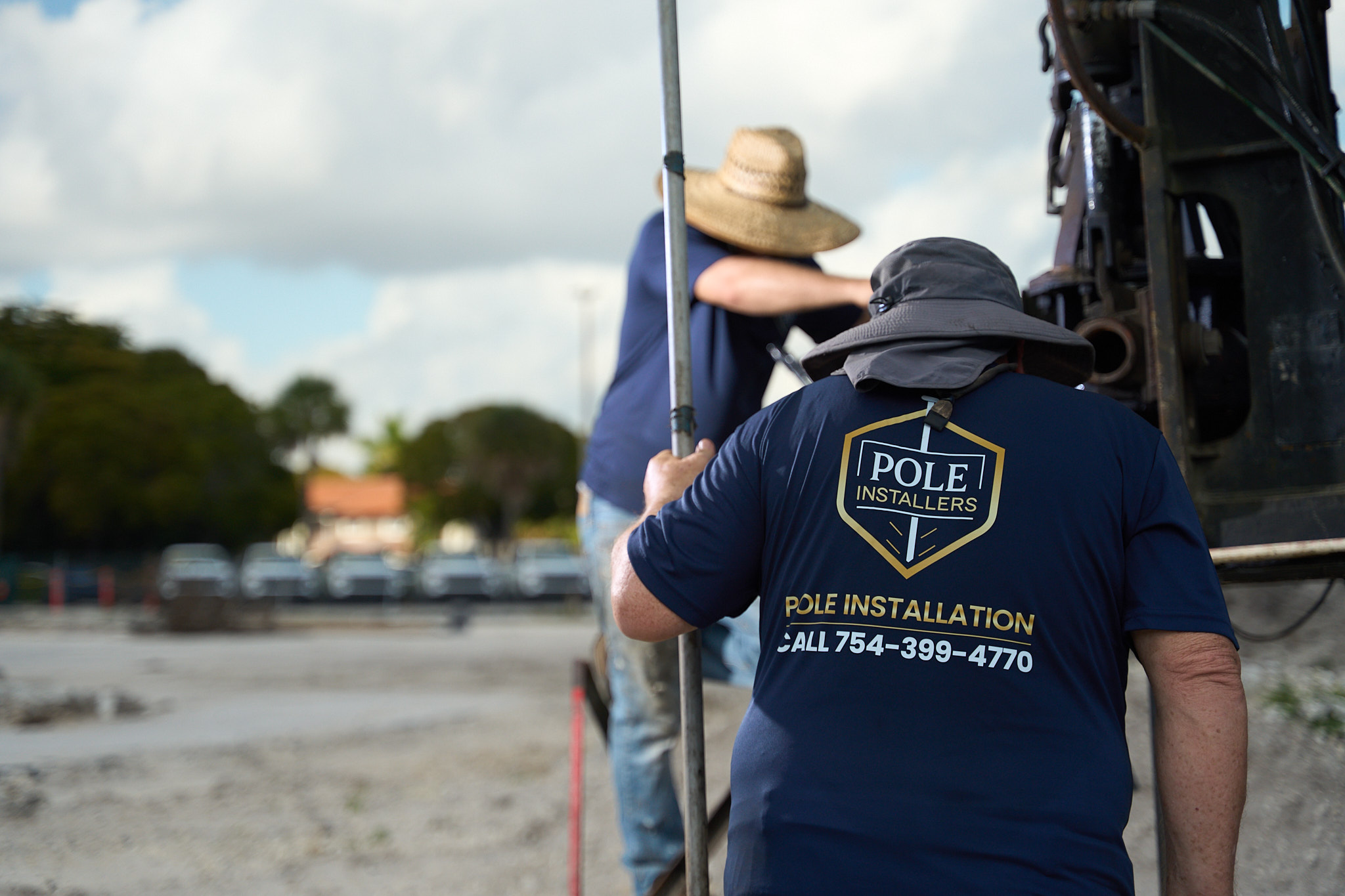 Pole Installers crew member guiding a pole into position