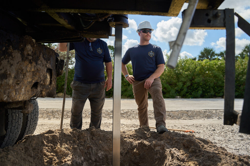 Pole Installers crew standing at a freshly set pole